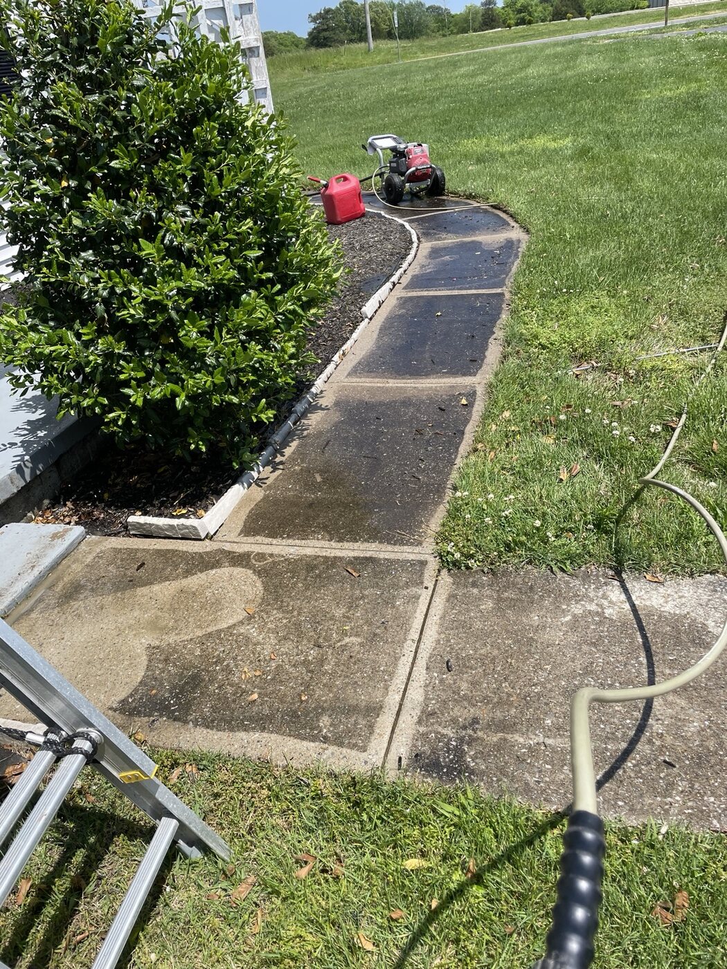 Dark dirty concrete walkway before pressure washing