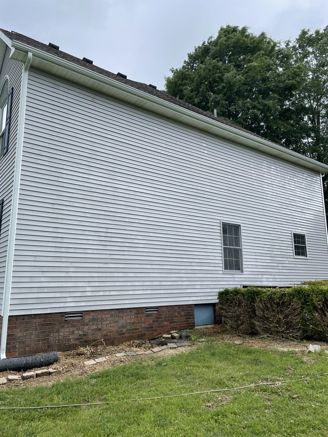 Clean two-story house siding after soft washing by Anderson Home Services